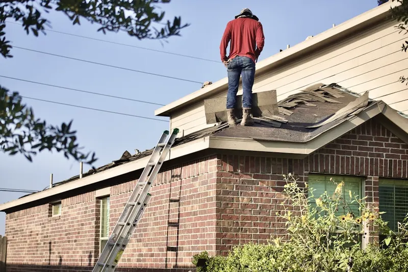 Professional roofer working on a residential roof in Manor Brook